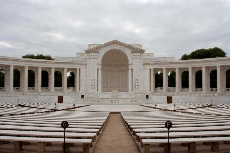 a large white building with columns and benches