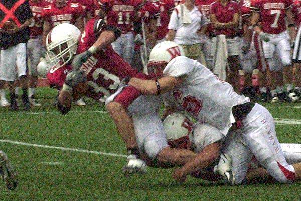 a football player falling into the tackle