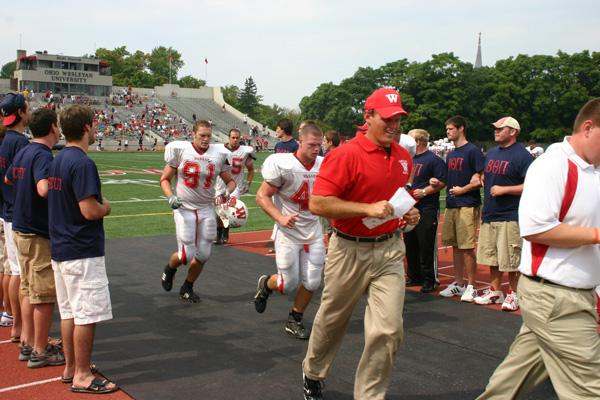 a football coach running with his team