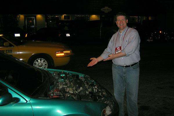 a man standing next to a car with his hands out