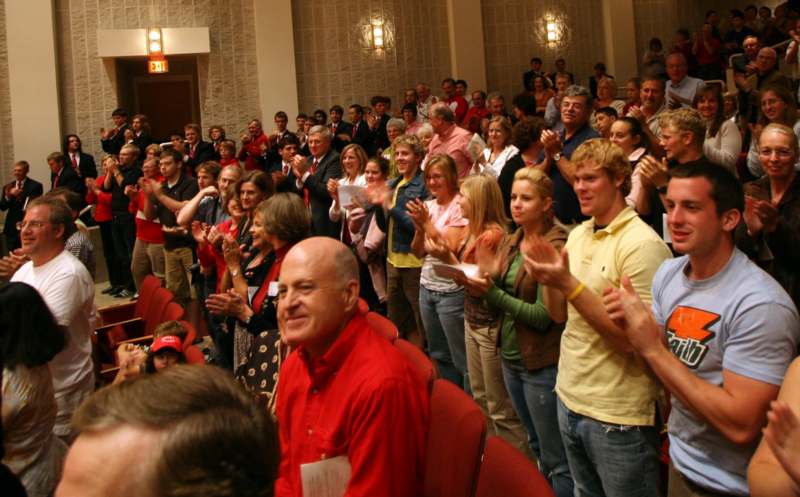 a group of people clapping in a room