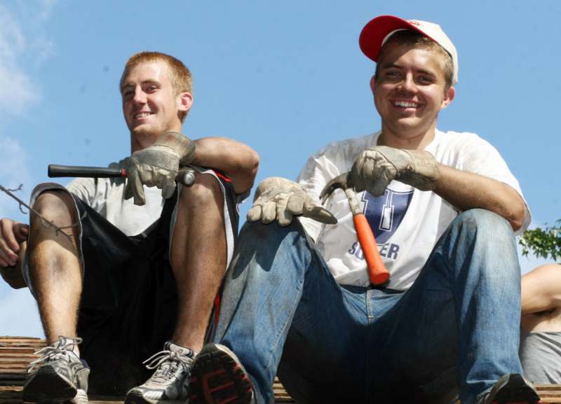 a couple of young men sitting on a ledge