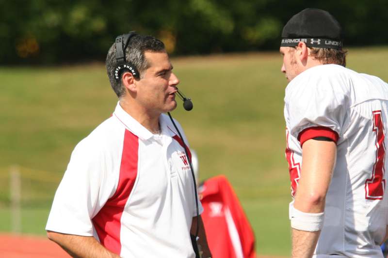 a football coach talking to another football player