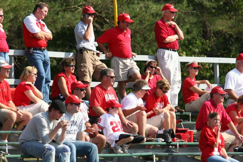 a group of people in red shirts sitting on bleachers