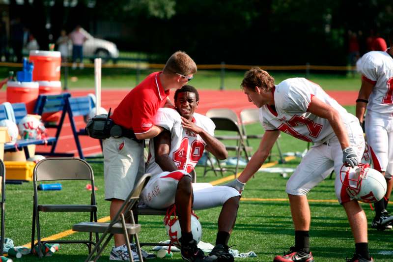a football player being helped by a coach