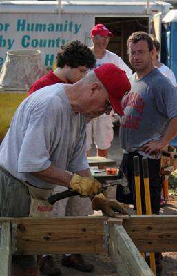 a group of men working on a wood plank