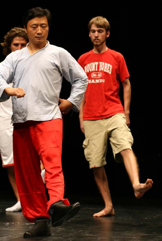 a man in red pants and a white shirt running on a stage