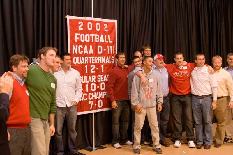 a group of men standing in front of a sign