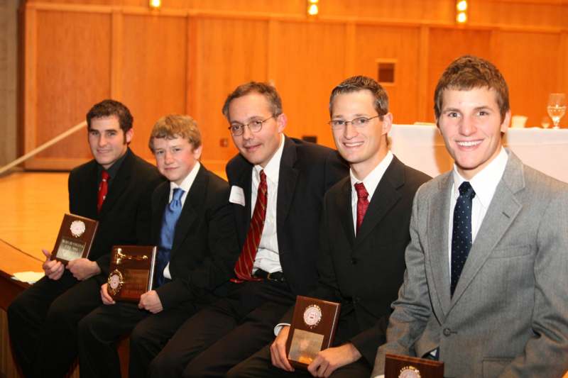 a group of men in suits holding awards