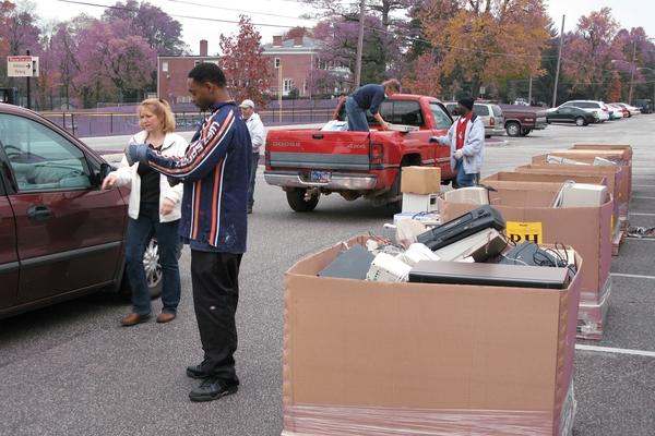 a group of people standing next to a pile of boxes