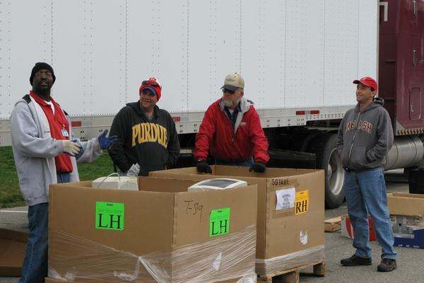 a group of men standing next to boxes