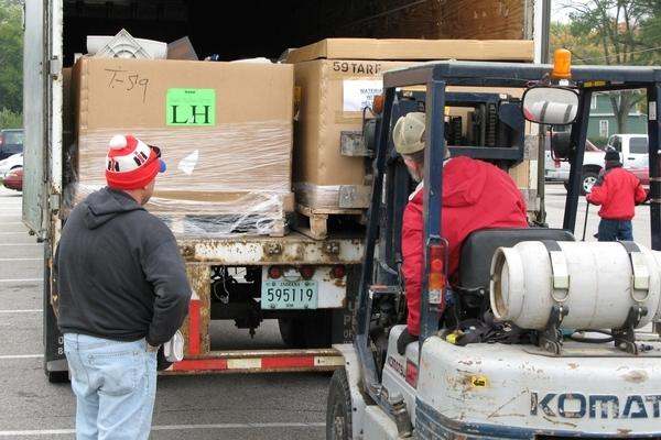 a man in a red jacket loading a truck