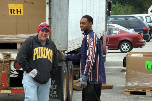 a couple of men standing next to a truck