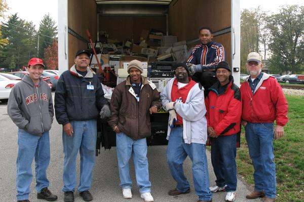 a group of men standing in front of a truck