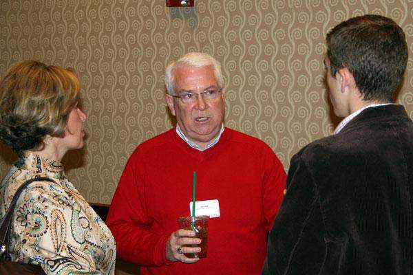 a man in a red sweater holding a drink