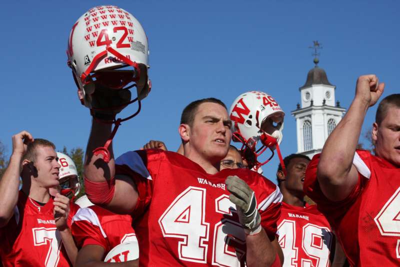 a group of football players holding helmets