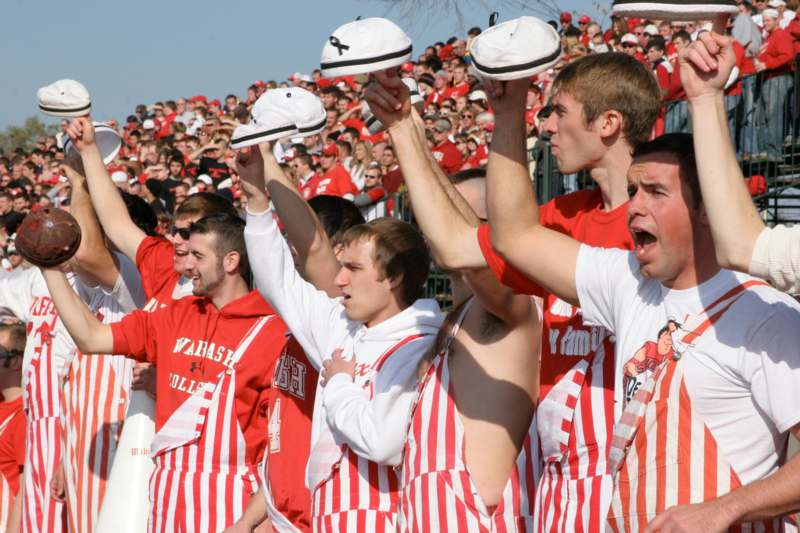 a group of men in red and white striped uniforms holding hats