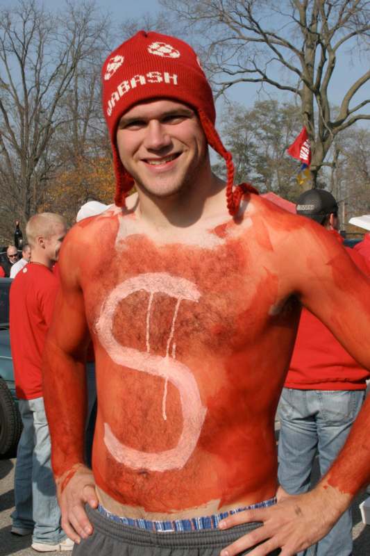 a man with a red hat and a dollar sign painted on his chest
