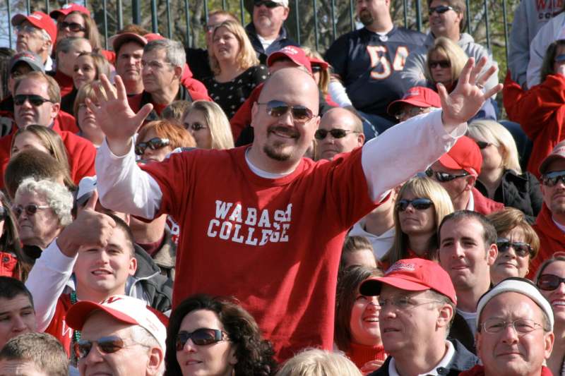 a man in a red shirt with his arms raised