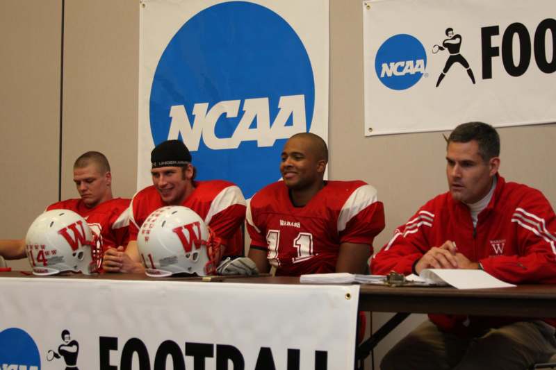 a group of football players sitting at a table