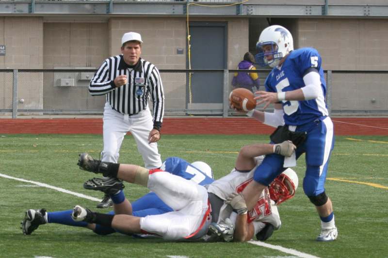 a football player being tackled by a referee