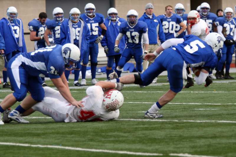 a football player falling over a player on the field