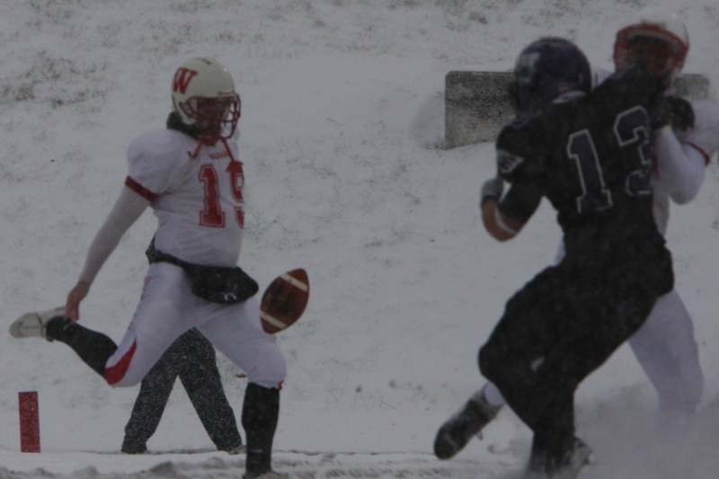 a football player running with a ball in the snow