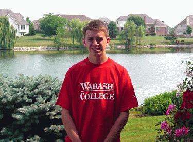 a young man standing in front of a lake