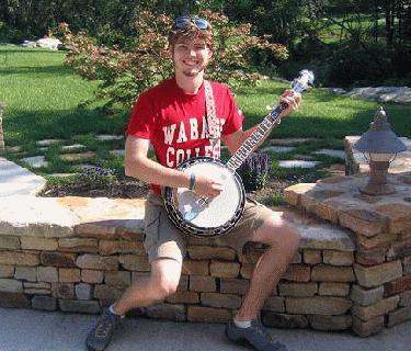 a man sitting on a brick wall playing a banjo