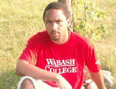 a man sitting in a grass field
