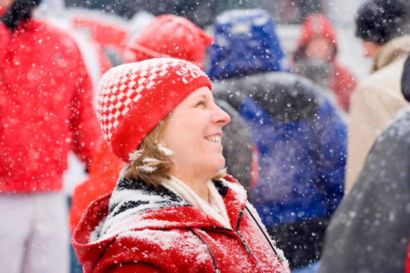 a woman in red and white hat and jacket in the snow