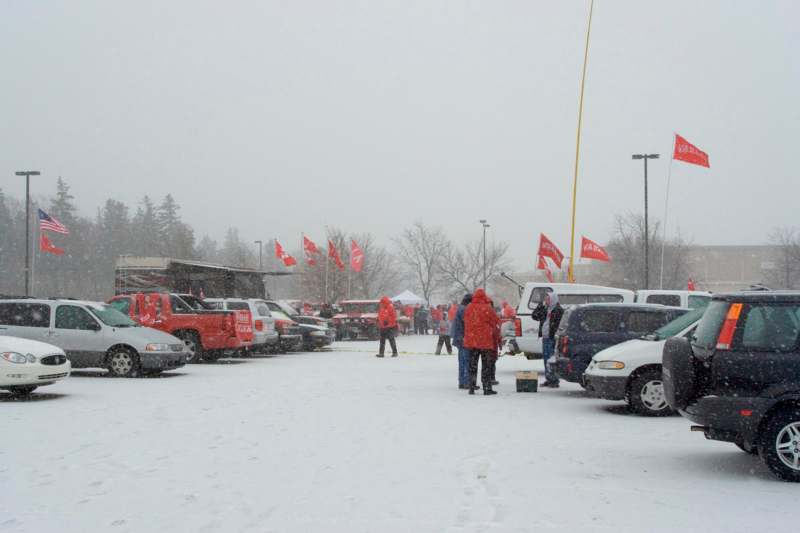 a group of people in a parking lot with flags