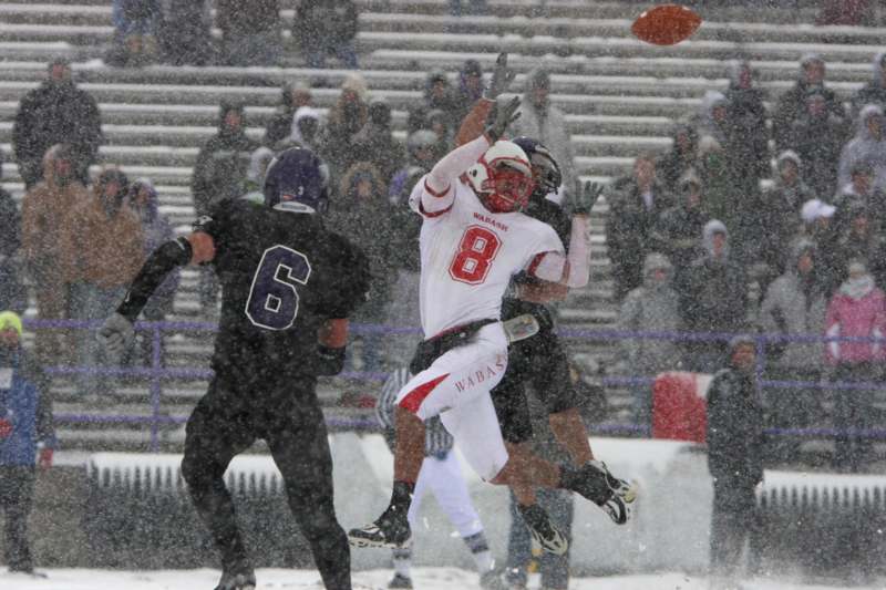 a football player catching a football in the snow