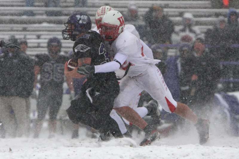 a group of football players running in the snow
