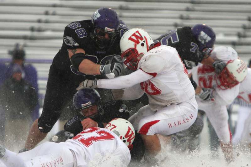 a group of football players in a snowy stadium