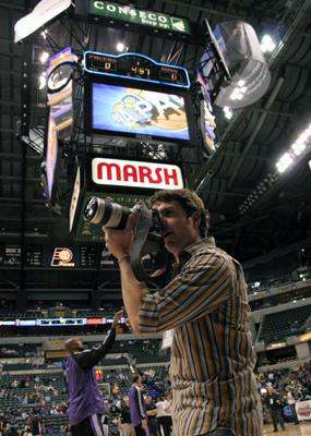 a man taking a picture of a basketball game