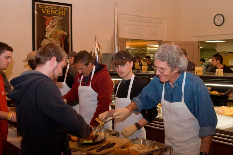 a group of people in aprons serving food