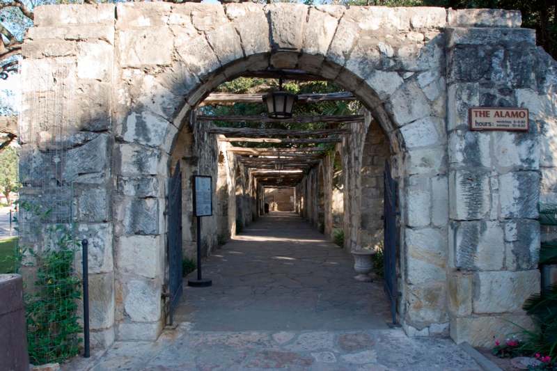 a stone archway with a light on the end