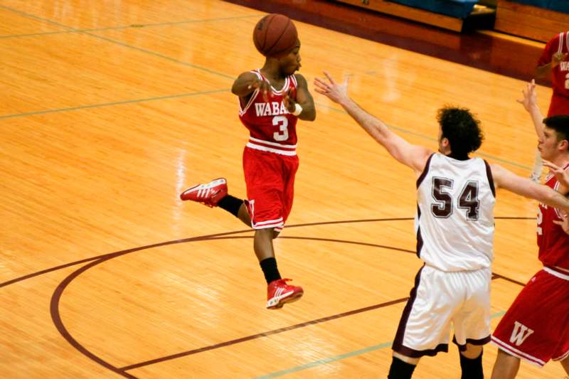 a basketball player in red and white uniform playing basketball