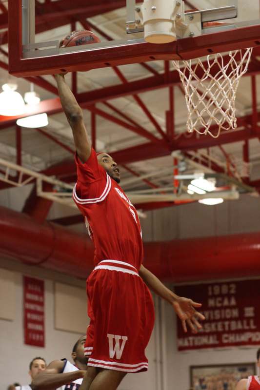a man in red uniform dunking a basketball hoop