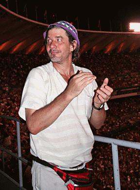 a man in a white shirt and purple hat