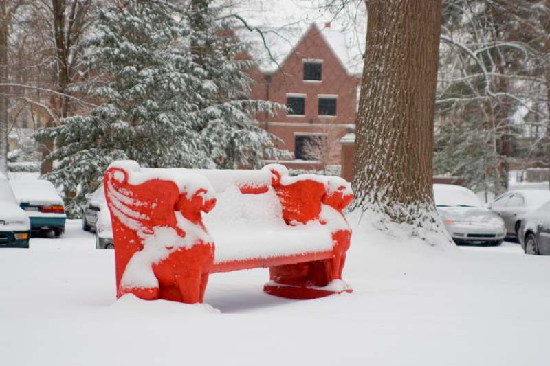 a red bench covered in snow