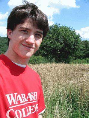 a young man in a field of tall grass