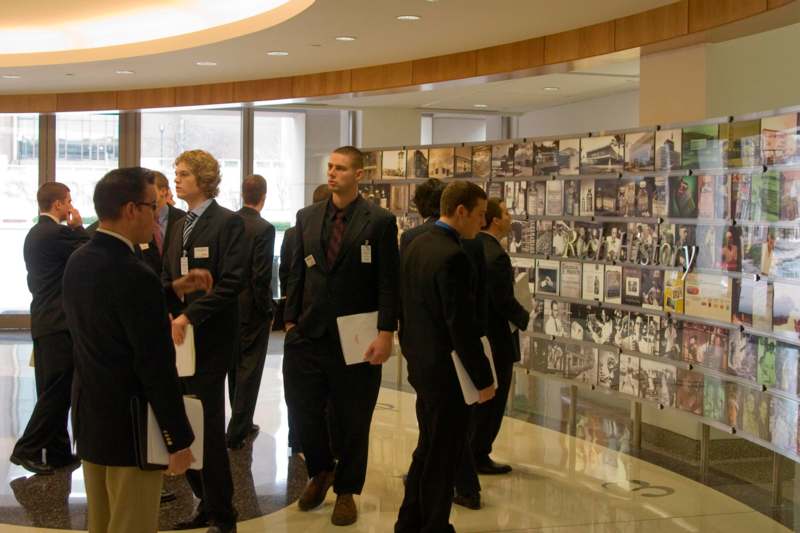 a group of men in suits looking at a display