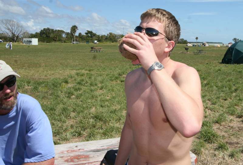 a man drinking from a coconut