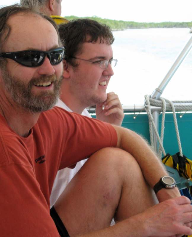 a man in sunglasses sitting next to another man on a boat