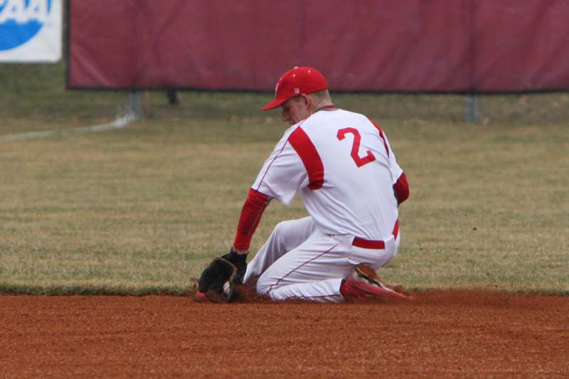 a baseball player kneeling on the ground