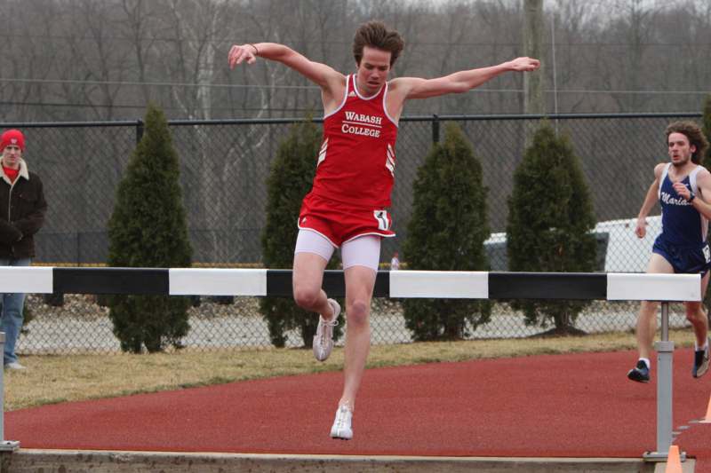 a person in a red uniform running on a track