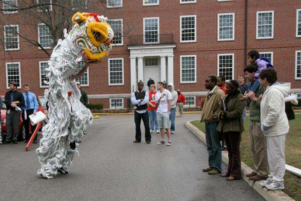 a group of people standing around a lion dance