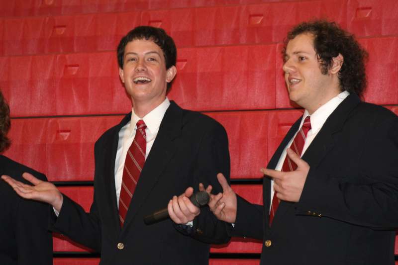 a couple of men in suits holding a microphone
